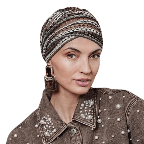 Frau trägt Sapphire Boho Turban mit gestricktem Muster in warmen Farbtönen und Goldfaden