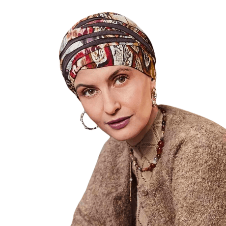 Frau trägt Shanti Turban im Tribal Feathers Muster, warme Herbstfarben und Federdesign. Kopfbedeckung mit Volumen