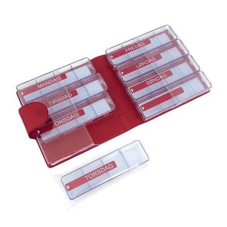 Rotes Kunstleder-Etui geöffnet mit sieben transparenten Dosierboxen und einer losen Box mit Wochentagen und Zeiten